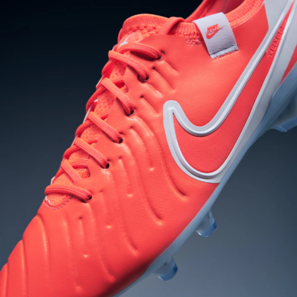 Chuteira de futebol Nike Tiempo Legend X Elite FG em cores vermelho e branco. Apresenta design moderno com cabedal FlyTouch+ macio e travas circulares para máxima tração e agilidade em campo.